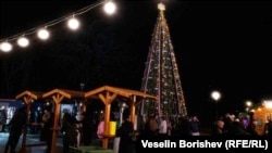 Коледната елха пред НДК е 6 метра и е украсена с играчки, ръчно изработени от деца от детски градини и домове за социални услуги. Светлините още не са запалени.