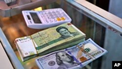 Gomila iranskih rijala pored hrpe američkih dolara. Nacionalna valuta Irana dostigla je rekordno nizak nivo 11. februara.