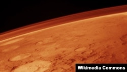 Space -- The tenuous atmosphere of Mars, visible on the horizon in this low-orbit photo, undated