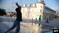 Një djalë duke luajtur me ujë të fontanave në sheshin e Prishtinës. (Foto nga arkivi) 