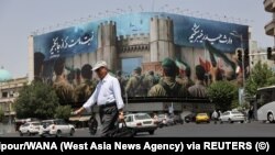 Muškarac prolazi pored antiizraelskog bilborda na ulici, tokom ranih sati prekida vatre, u Teheranu, Iran, 24. juna 2025.