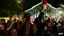 Mbështetësit e kryetarit të Bukureshtit, Nicușor Dan, brohorasin teksa ai del nga selia e fushatës në Bukuresht, më 18 maj 2025.