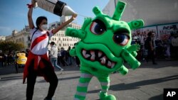 Új koronavírusnak öltözött színész egy utcai előadáson Limában 2020. november 14-én.