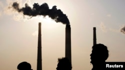 Луѓето поминуваат покрај електрана во Шангај (илустрација)