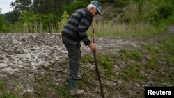 Un localnic coboară cu grijă pe albia pârâului Corund după inundațiile de la sfârșitul lunii mai, la Praid