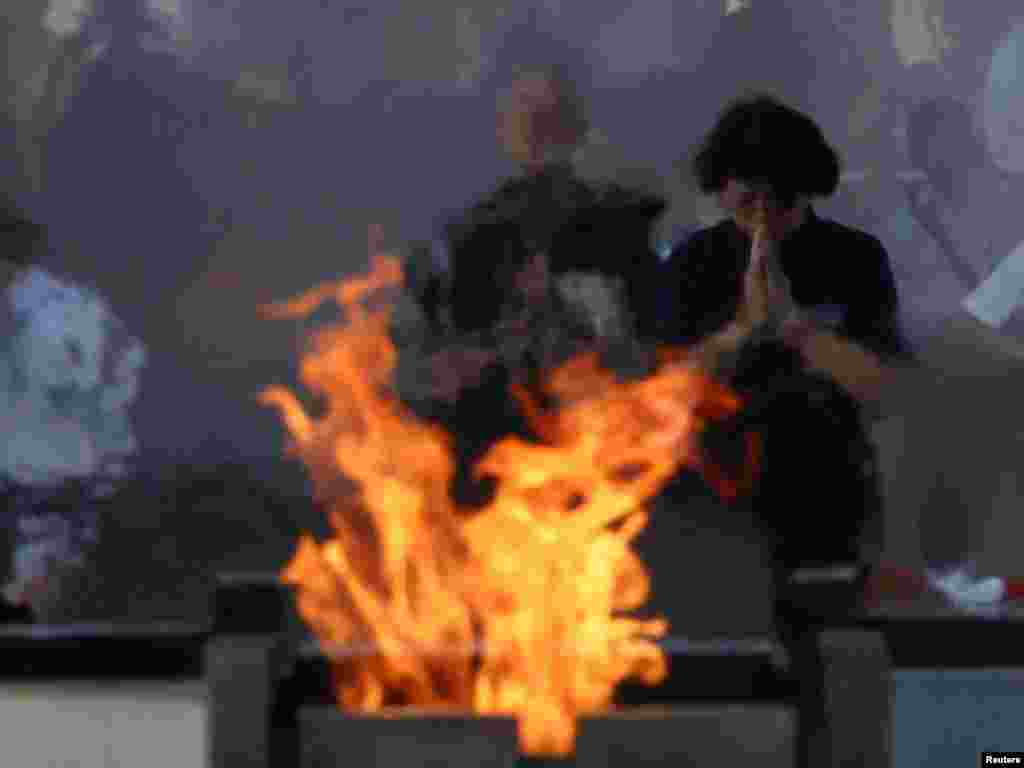 Ljudi se mole ispred kenotafa za žrtve atomskog bombardiranja 1945. godine, u Memorijalnom parku mira u Hirošimi, na 80. godišnjicu Dana atomskog bombardiranja u Hirošimi, zapadni Japan, 6. avgusta 2025.