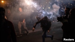 Протестиращ хвърля димка по време на сблъсъци в Белград, 2 ноември 2025 г.