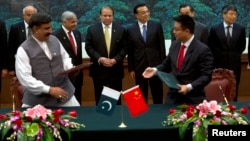 File photo of Pakistani Prime Minister Nawaz Sharif (center L) and Chinese Premier Li Keqiang (center R) observe a signing ceremony.