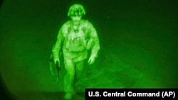 Në këtë fotografi të publikuar nga Komanda Qendrore e SHBA-së, gjeneral major Chris Donahue hip në një aeroplan në Aeroportin Ndërkombëtar Hamid Karzai në Kabul, Afganistan, e hënë, 30 gusht 2021, si anëtari i fundit i shërbimit amerikan që u largua nga Afganistani.