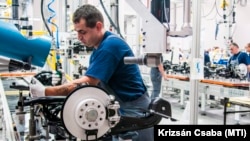 Összeszerelő munkás dolgozik a szalag mellett egy futóművön a ThyssenKrupp győri üzemében 2013. június 21-én
