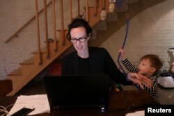 Një nënë në SHBA duke tentuar të punojë nga shtëpia në prani të djalit të saj.