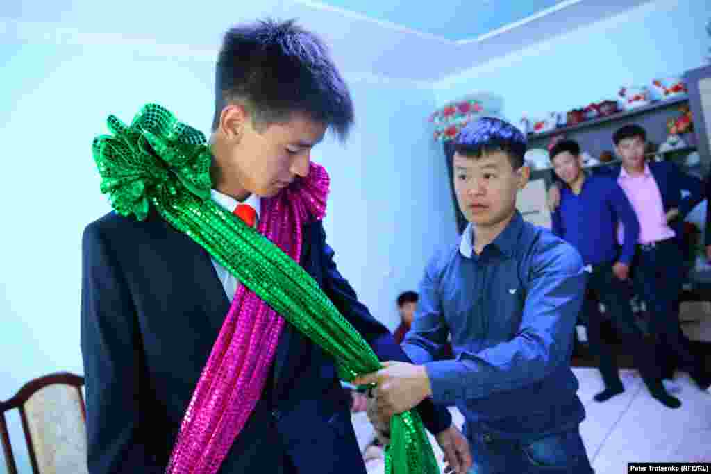 In the meantime, Shafur is getting ready to pick up the bride.&nbsp;Friends help to put red and green ribbons on his suit --&nbsp;the distinctive emblems of the groom.