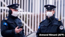 Илустрација - Полицајци со заштитни маски во Приштина