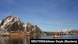 Halászhajó érkezik az egyik Északi-sarkkörön túli norvég szigeten lévő Svolvaer városka kikötőjébe 