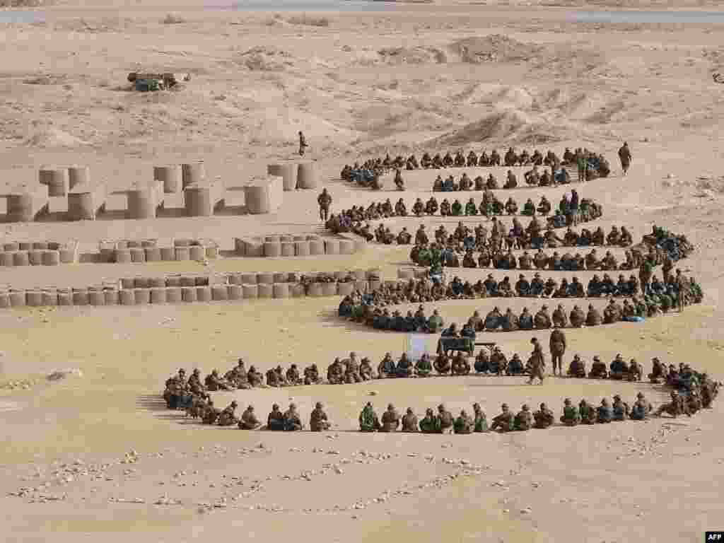 Војници на Авганистанската Национална Армија седат на земја во тренинг центарот во Кабул, на 11 јануари, во текот на посетата на американскиот потпретседател, Џо Бајден 